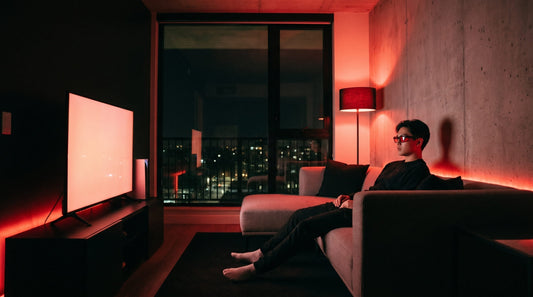Persona con gafas nocturnas rojas Krudo viendo la televisión por la noche con iluminación roja ambiental