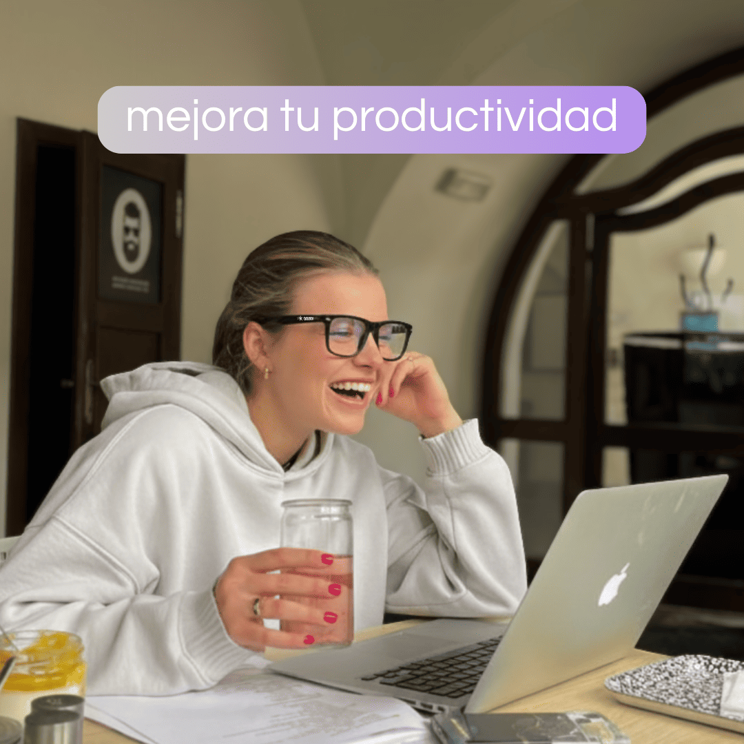 Mujer trabajando con portátil y gafas con filtro de luz azul de Krudo, riendo y mostrando mayor comodidad visual y productividad frente a las pantallas.