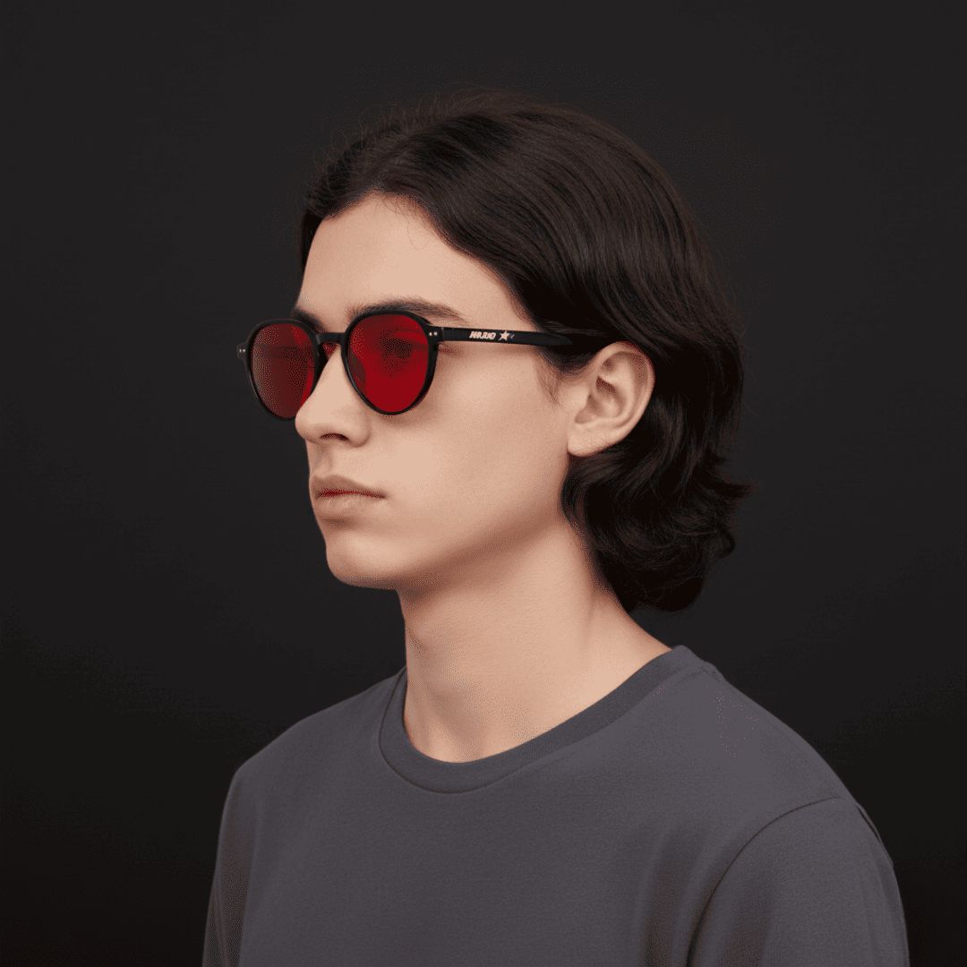 Hombre con gafas Krudo Night Core con lentes rojas bloqueadoras de luz azul, ideales para usar de noche y mejorar la calidad del sueño reduciendo la exposición a pantallas.